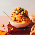 Bowl with scoops of vegan apricot sorbet topped with candied pistachios