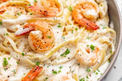 Close up overhead view of shrimp Alfredo in a bowl.