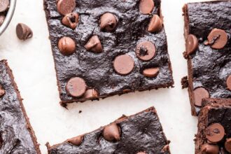 Chocolate chip avocado brownies spread out on a white counter top.