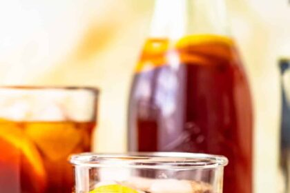 homemade sweat tea in a glass in front of a pitcher of sweet tea