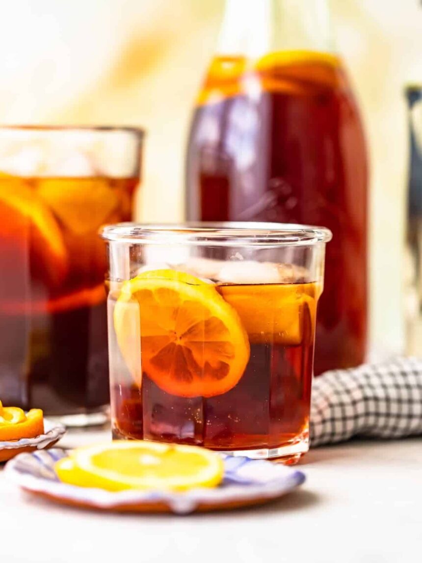 homemade sweat tea in a glass in front of a pitcher of sweet tea