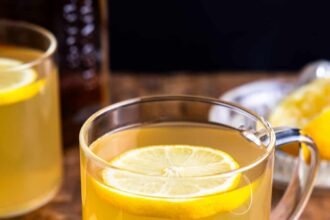 A cup of lemon tea with a slice of lemon.