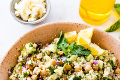 A salad inspired by Jennifer Aniston in a large bowl with quinoa, chickpeas, fresh herbs, and vegetables.