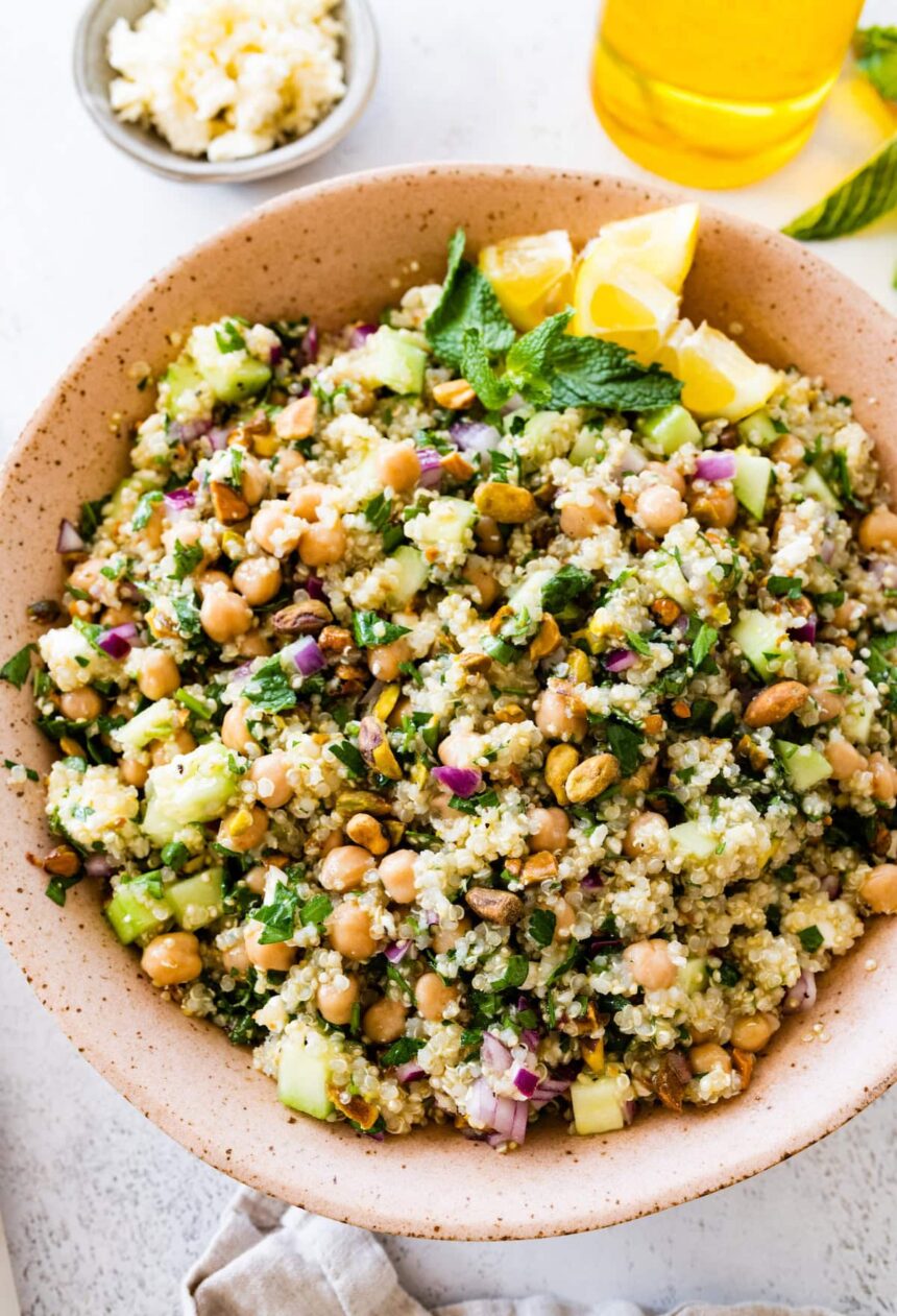 A salad inspired by Jennifer Aniston in a large bowl with quinoa, chickpeas, fresh herbs, and vegetables.