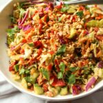 Rainbow crunch salad in a large white bowl, with a fork.