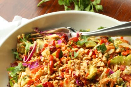 Rainbow crunch salad in a large white bowl, with a fork.