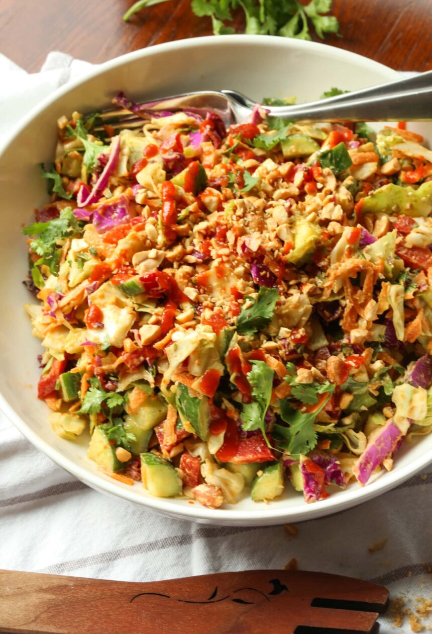 Rainbow crunch salad in a large white bowl, with a fork.