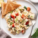 Scrambled egg whites on a plate with two pieces of toast on the side.