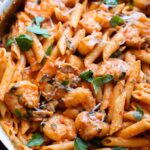 Creamy Shrimp Pasta in a large skillet with a fresh basil garnish