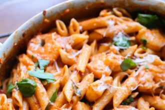 Creamy Shrimp Pasta in a large skillet with a fresh basil garnish