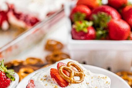 A slice of strawberry pretzel salad on a stack of plates.