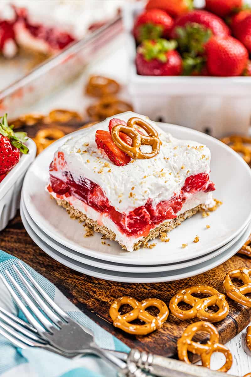 A slice of strawberry pretzel salad on a stack of plates.