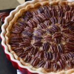 A Pecan Tart in a red ceramic tart pan