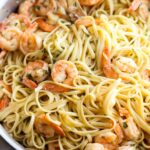 Shrimp scampi in a pan with linguine.