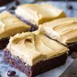 Brownies cut into squares, topped with peanut butter frosting