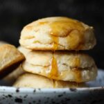 Yeast Biscuits stacked on a plate with honey dripping down the top.