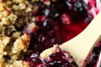 Blueberry Crisp in a baking dish with a spoon to serve