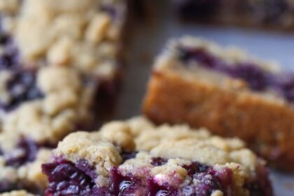 Close up of Blueberry Crumb Bars stacked on a countertop.