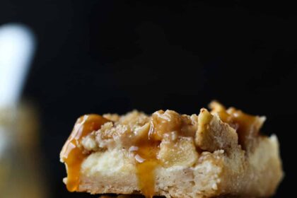 A stack of 3 Caramel Apple Cheesecake Bars on a wire rack