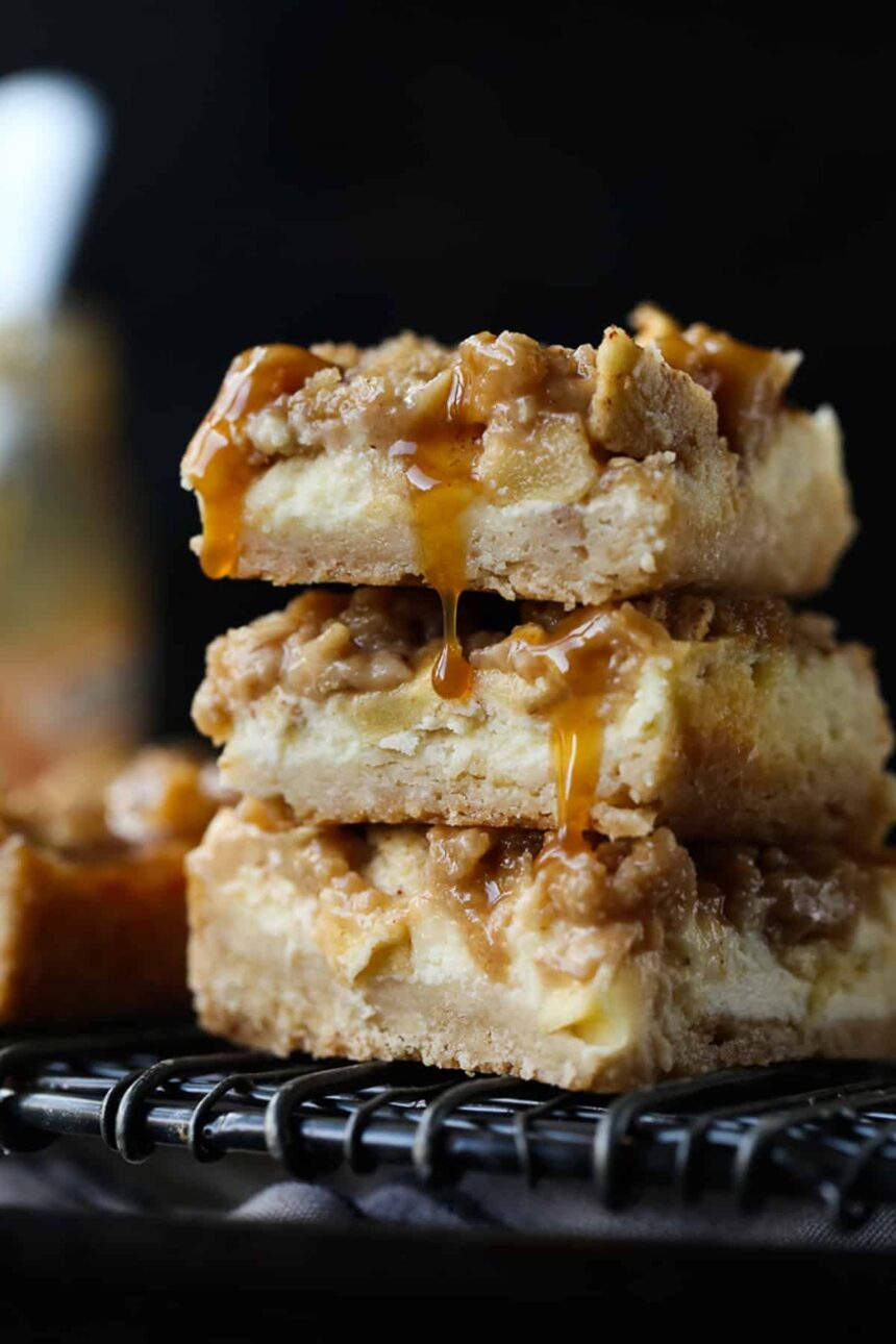 A stack of 3 Caramel Apple Cheesecake Bars on a wire rack