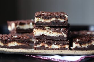 Three Cheesecake Brownies Stacked on Top of Each Other on a Serving Tray