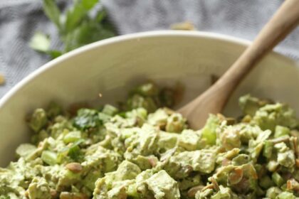 Green goddess chicken salad in a large bowl with a wooden spoon.