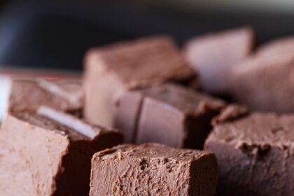 Chocolate fudge squares stacked in a bowl.