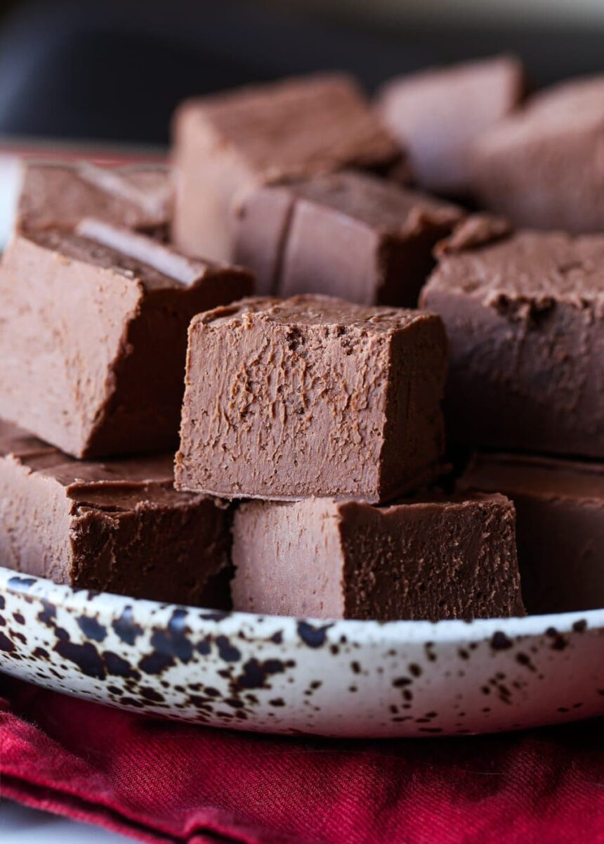 Chocolate fudge squares stacked in a bowl.