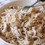 Shredded chicken breast in a bowl with forks