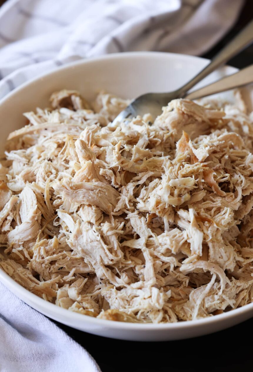 Shredded chicken breast in a bowl with forks