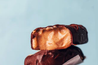 Stack of creamy vegan peanut butter ice cream bars coated in chocolate
