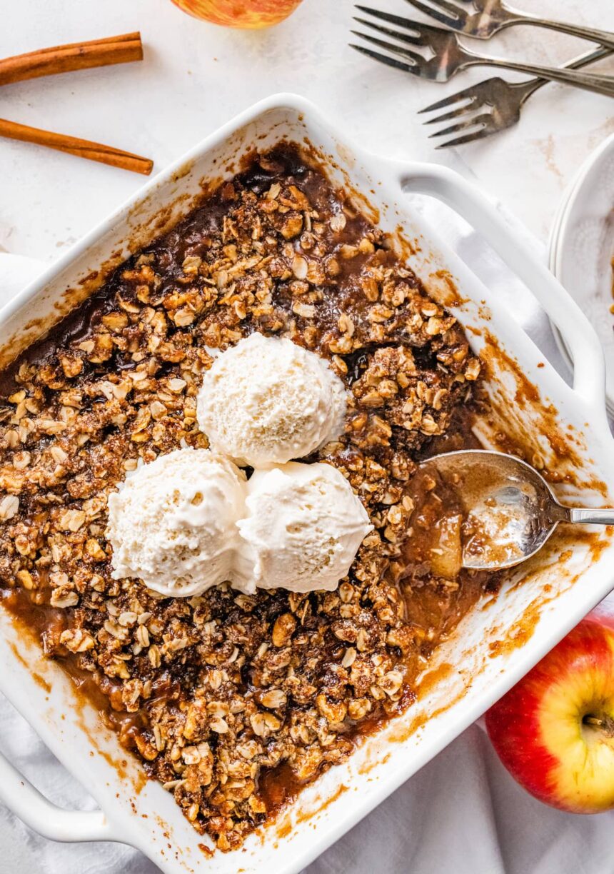 A healthy apple crisp topped with three scoops of ice cream.