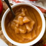 Homemade applesauce in a bowl with a metal spoon.