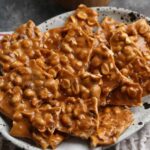 Homemade peanut brittle served on a plate.