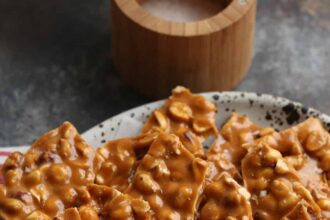 Homemade peanut brittle served on a plate.