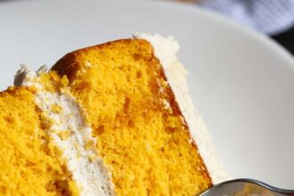 A slice of pumpkin cake with a fork taking a bite