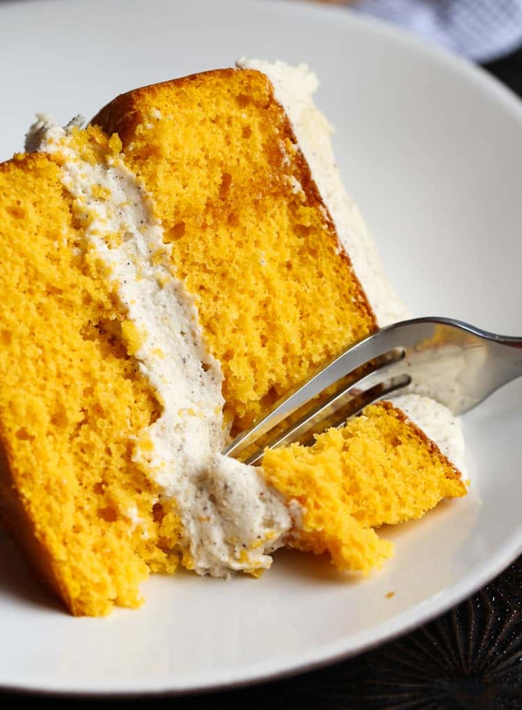 A slice of pumpkin cake with a fork taking a bite