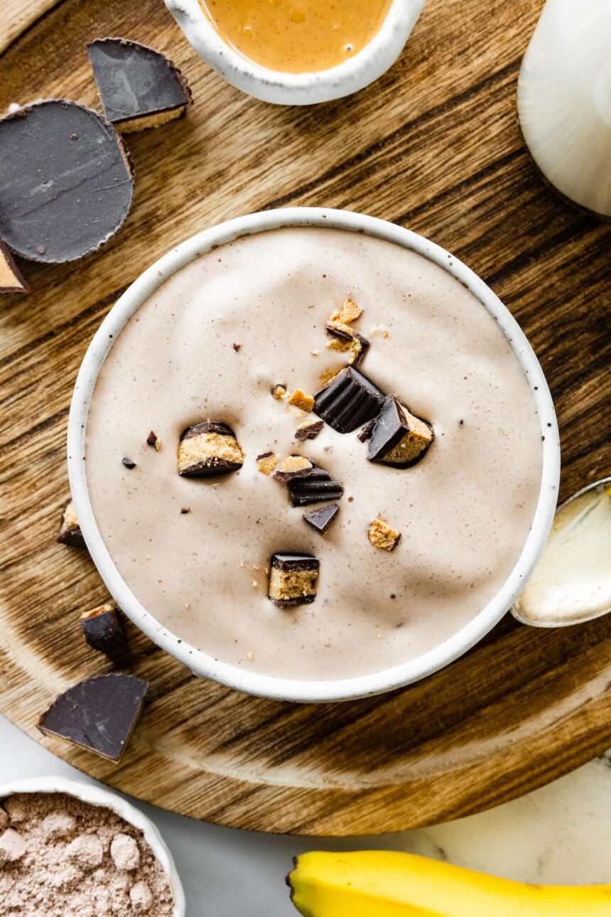 A bowl full of peanut butter cup protein fluff topped with chunks of peanut butter cups.