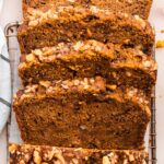 Four slices of pumpkin banana bread lean against one another on a cooling rack.