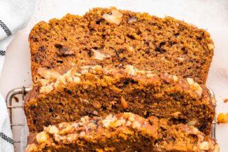 Four slices of pumpkin banana bread lean against one another on a cooling rack.