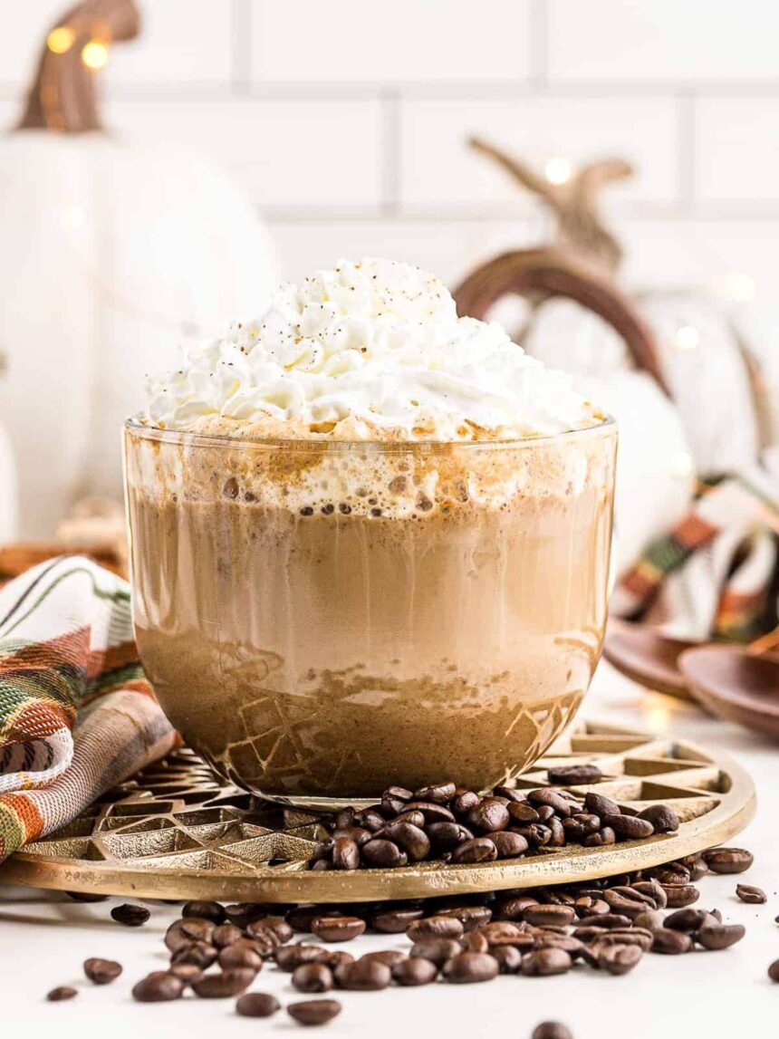 large clear mug with pumpkin spice latte topped with whipped cream