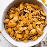 A bowl of roasted and salted pumpkin seeds.