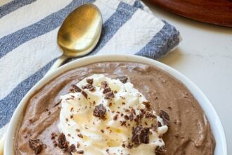 A small white bowl with chocolate pudding. There