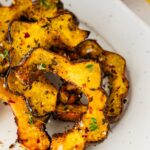 Roasted acorn squash served on a white plater.