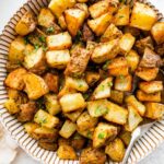 Roasted potatoes garnished with fresh parsley in a bowl.