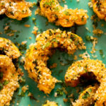 Close up photo of roasted delicata squash coated a garlic & herb breading