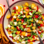 Serving spoons resting in a bowl of our easy winter fruit salad recipe