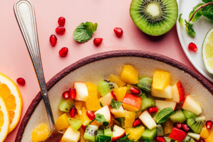 Serving spoons resting in a bowl of our easy winter fruit salad recipe