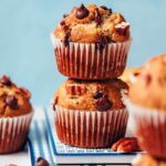 Stack of vegan gluten-free banana chocolate chip muffins dripping with melty chocolate