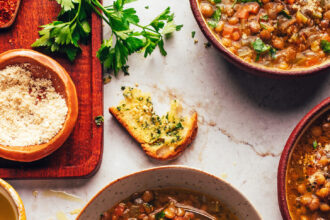 Bowls of Italian lentil soup with slices of garlic bread